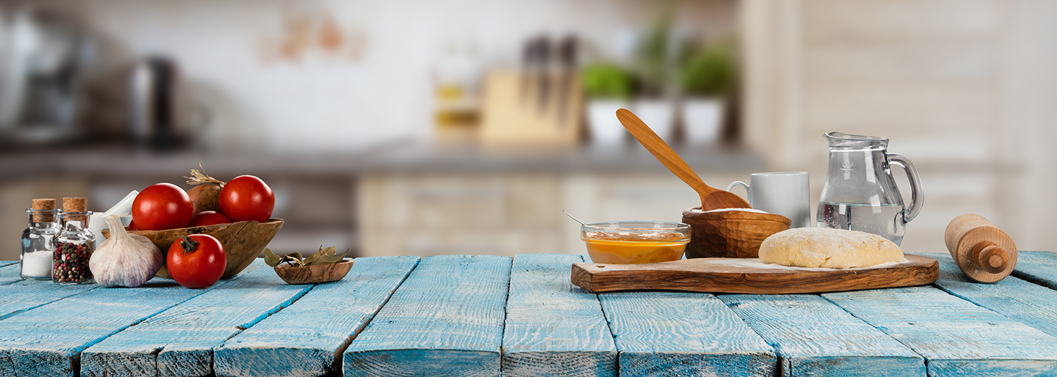 Tisch mit Tomatenschale und Brett